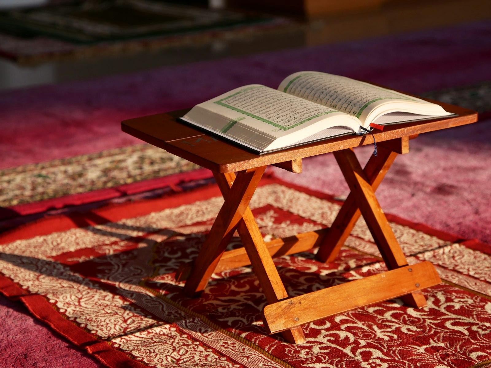 An open Qur'an on a wooden stand in a mosque